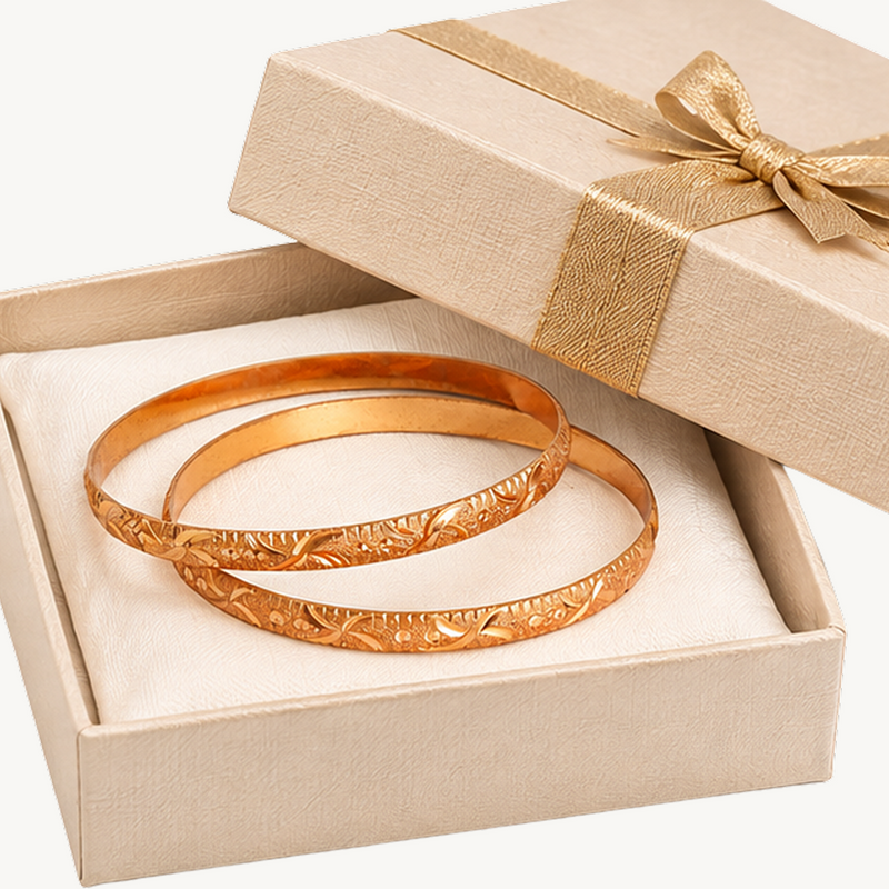 Gold-coloured floral vine bangles displayed in a gift box
